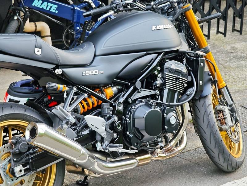 Close-up of the engine, gold forks and exhaust of a Kawasaki motorcycle