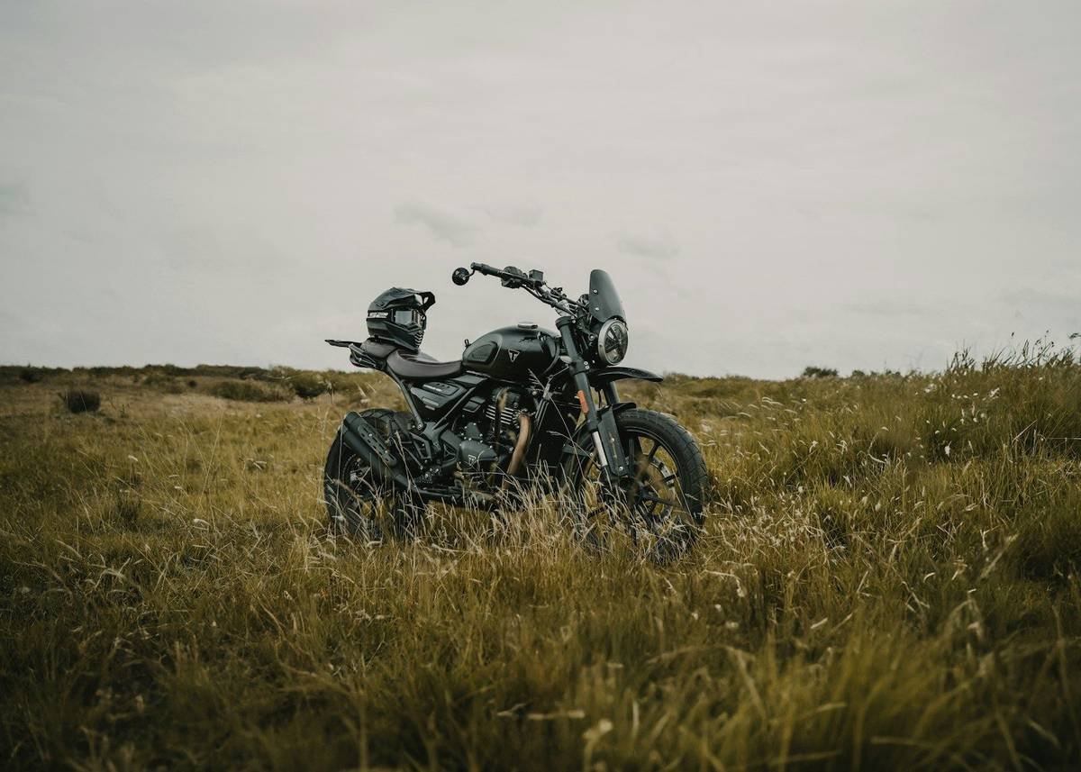 A scrambler-style motorcycle parked in long grass